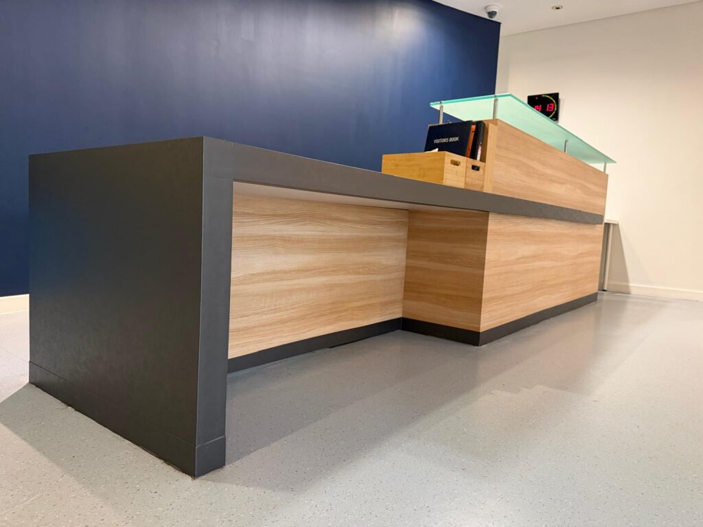 Behind the Wrap: How We Transform a Busy Commercial Space Without the Disruption - Signwrite Studios Nucleus Network Reception Desk 3M DINOC Architectural Film Solution Wrap